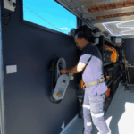 Electrician installing a wall-mounted EV charger inside a residential garage
