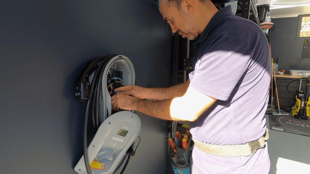 Close-up of electrician wiring a home EV charger unit