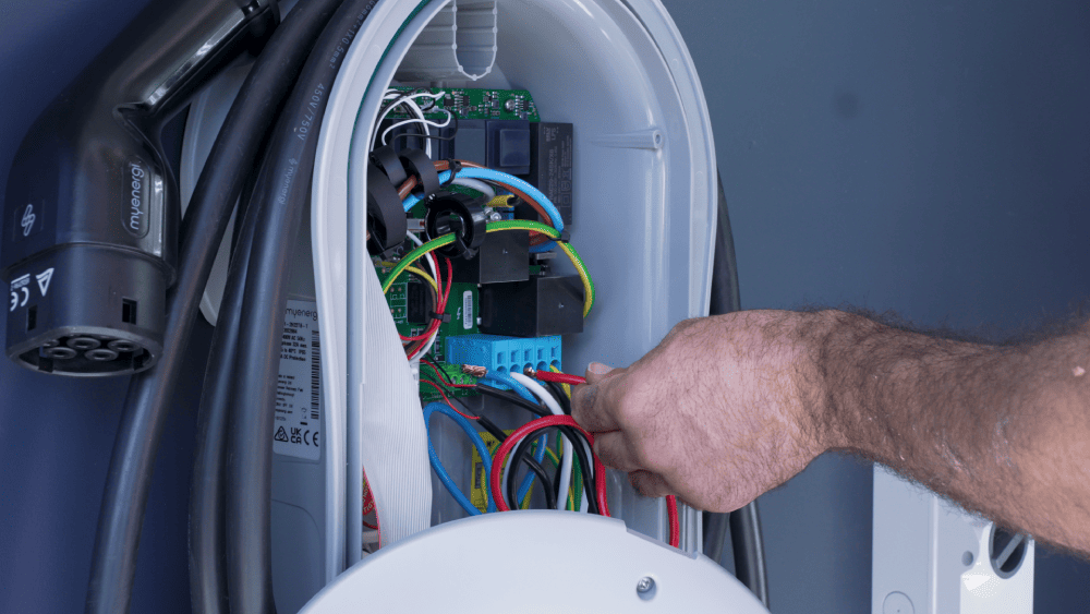 Close-up of electrician completing EV charger wiring and electrical connection