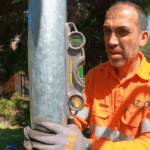 Level 2 electrician positioning galvanised private power pole for installation