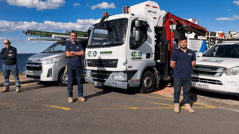 IZCO Electrical team standing with equipped service vehicles for electrical work