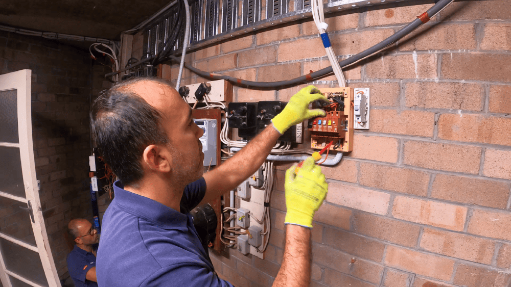 Electrician installing meter protection device on switchboard