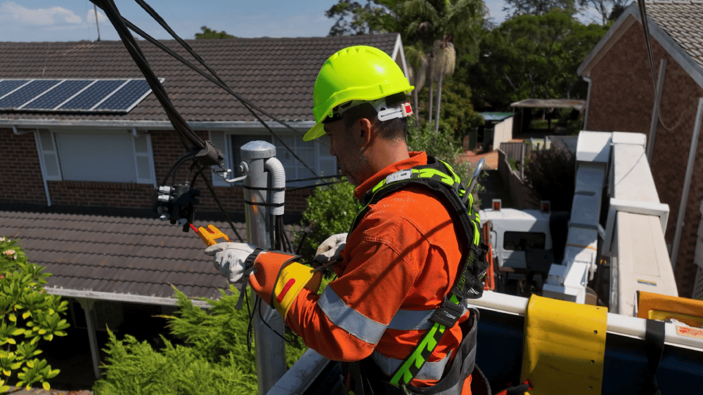 Level 2 electrician repairing overhead electrical cables from elevated platform