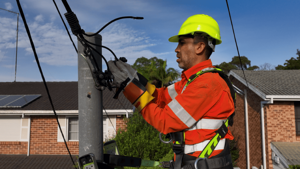 Level 2 electrician working on overhead power connection on a service pole