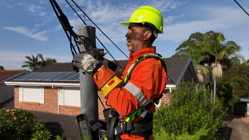 Level 2 electrician repairing overhead service cables on power pole