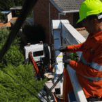Electrician repairing point of attachment for overhead power supply