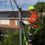 Electrician inspecting point of attachment for overhead electrical supply