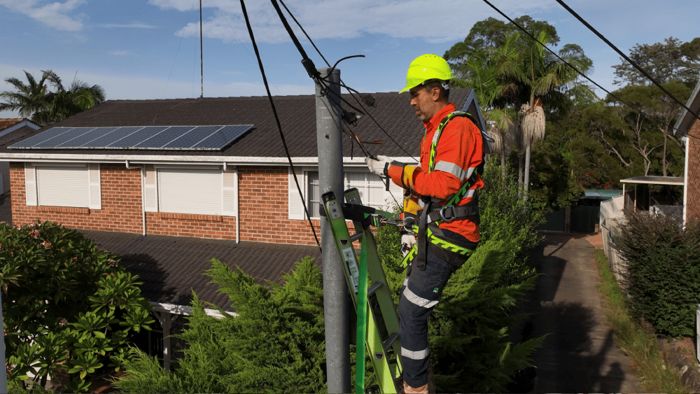Electrician inspecting point of attachment for overhead electrical supply