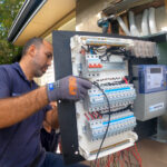 Electrician upgrading switchboard with meter and circuit protection devices