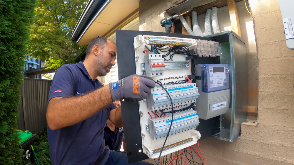 Electrician upgrading switchboard with meter and circuit protection devices