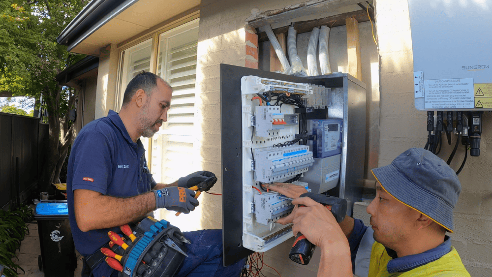 Electricians testing upgraded switchboard and meter panel at residential property