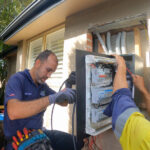 Electricians upgrading residential switchboard and electrical meter panel